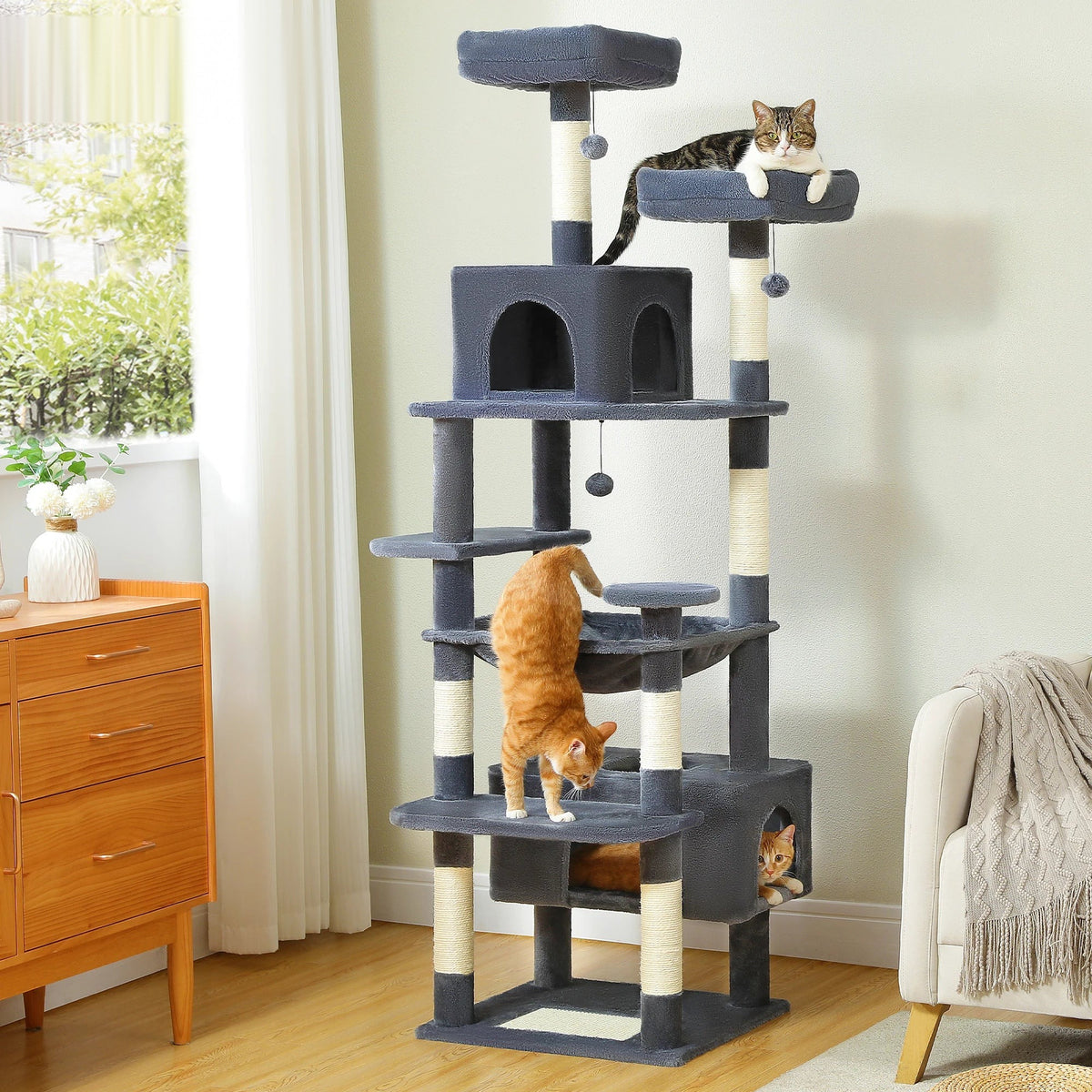 Grand arbre à chat en sisal avec niches et hamac, installé près d'une fenêtre